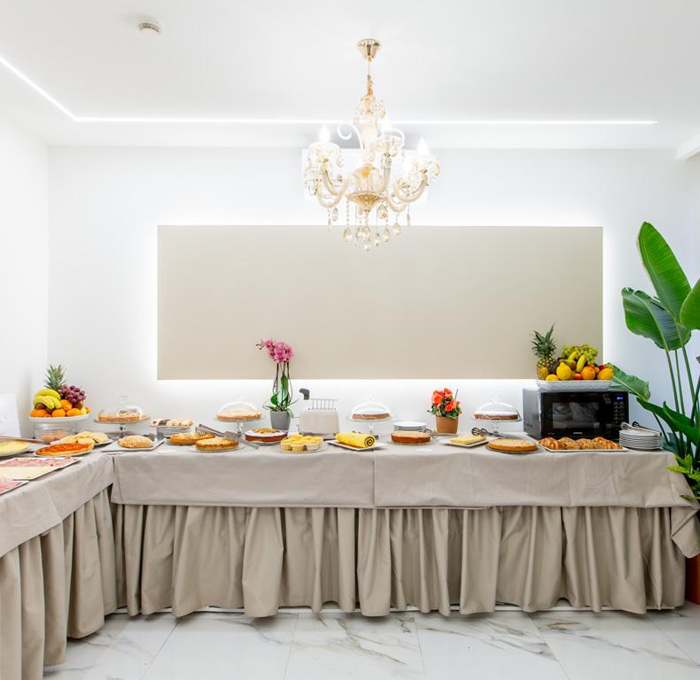 Buffet di dolci con frutta fresca in una sala elegante.