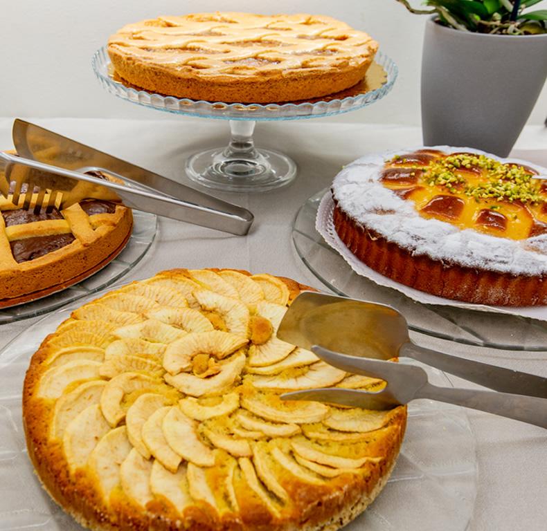 Quattro torte deliziose su un tavolo, pronte per essere servite.