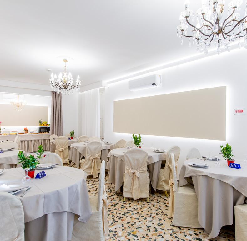 Ristorante elegante con decorazioni raffinate e tavoli apparecchiati in una sala luminosa.